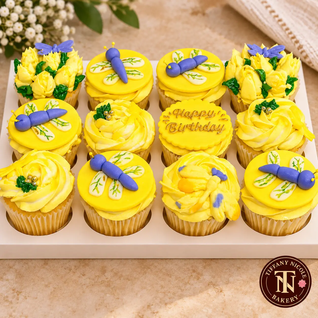 Yellow birthday cupcakes with dragonfly toppers and Happy Birthday medallion